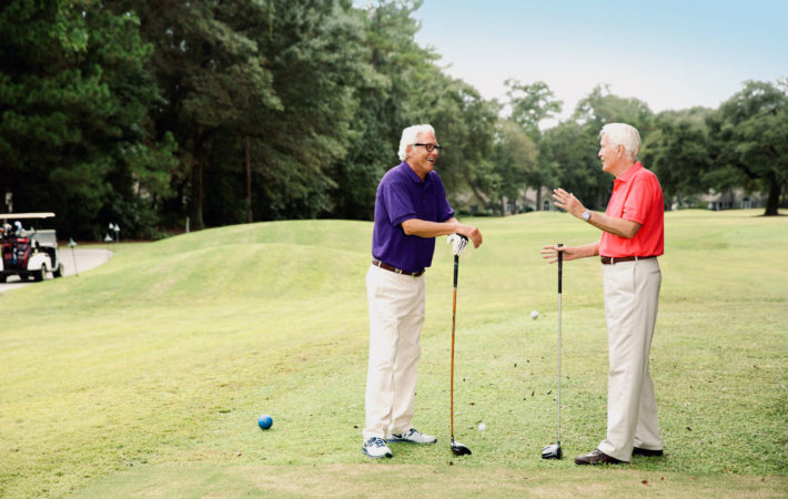 Two men chat at a golf course